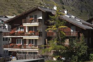 ツェルマットにあるスイスフレア アパートメントのバルコニーと山のあるアパートメントビル