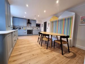 uma cozinha com uma mesa de madeira e cadeiras em Salt & Surf-Sea Views in Saltburn em Saltburn-by-the-Sea