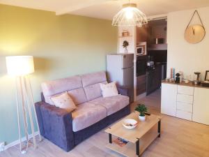 a living room with a couch and a table at Détente au Cœur de la Station in Métabief