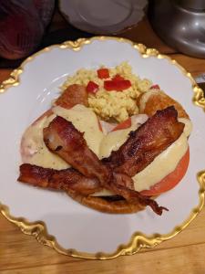 a plate of food with bacon and eggs on a table at Maple Hill Manor Bed & Breakfast in Springfield