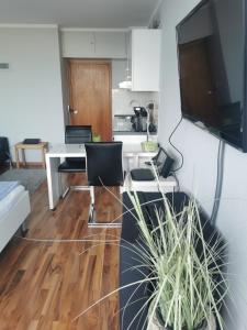 eine Küche und ein Wohnzimmer mit einem Schreibtisch und Stühlen in der Unterkunft Lieblingsstrand App20 in Travemünde direkt am Strand in Travemünde