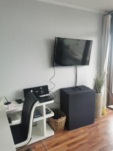 ein Wohnzimmer mit einem TV an einer Wand mit einem Stuhl in der Unterkunft Lieblingsstrand App20 in Travemünde direkt am Strand in Travemünde