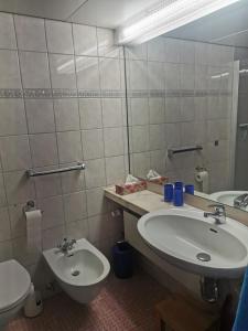 ein Badezimmer mit einem Waschbecken, einem WC und einem Spiegel in der Unterkunft Lieblingsstrand App20 in Travemünde direkt am Strand in Travemünde