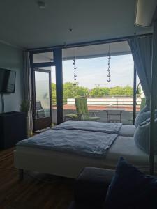 ein Schlafzimmer mit einem großen Bett und einem großen Fenster in der Unterkunft Lieblingsstrand App20 in Travemünde direkt am Strand in Travemünde