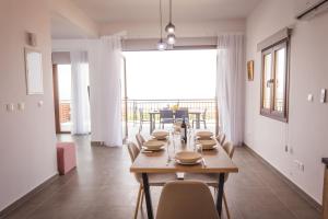 uma sala de jantar com mesa e cadeiras e uma grande janela em Villa Aeria em Lyso