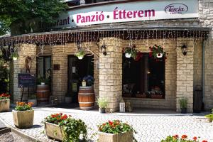 a restaurant with flowers in front of a building at Tercia Hubertus Panzió in Sopron