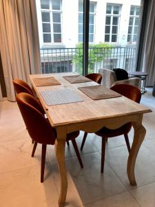 a wooden table with chairs in a room at Apartment in the Heart of Ghent in Ghent