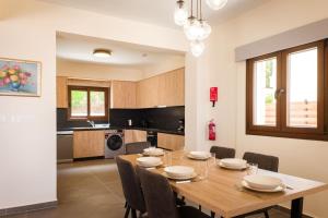 a kitchen and dining room with a wooden table and chairs at Villa Kition in Lyso