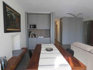 a dining room with a table and a kitchen at Les fleuves - Buthier in Aosta