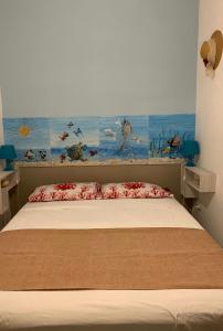 una camera da letto con un letto e un dipinto sul muro di Casa di nonna Benedetta a Margherita di Savoia