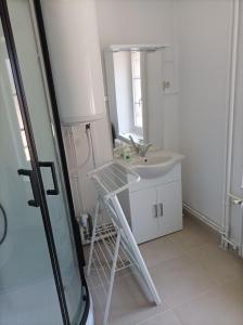 uma casa de banho branca com um lavatório e um espelho em O'Couvent - Appartement 80m2 - 2 chambres - A331 em Salins-les-Bains