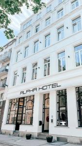 a white building with a sign on the front of it at Alpha Hotel in Ostend