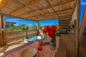 a table with flowers on a balcony with a pool at Glamping Gli Etruschi in Piombino
