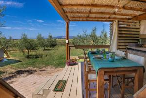 a table and chairs on a patio with a view at Glamping Gli Etruschi in Piombino
