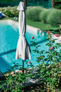 um guarda-chuva branco sentado ao lado de uma piscina em Sotto un cielo di Stelle em Turim