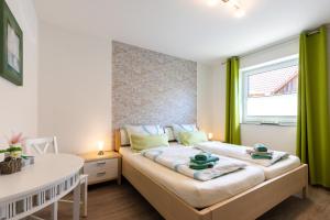 a bedroom with a bed with two green towels on it at Ferienhaus Südheide in Hermannsburg