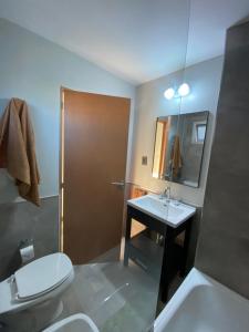 uma casa de banho com um WC, um lavatório e um espelho. em Hermoso departamento céntrico con estacionamiento em Paraná