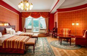sypialnia z dwoma łóżkami, stołem i krzesłami w obiekcie Spa Hotel Imperial w Karlowych Warach