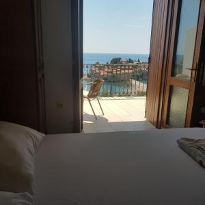 a bedroom with a bed and a view of a balcony at Vila Horizont in Sveti Stefan
