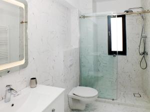 a bathroom with a toilet and a glass shower at Ada Luxury Apartments 43 in Mamaia +4 photos