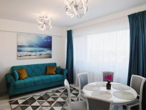 a living room with a green couch and a table at Ada Luxury Apartments 43 in Mamaia