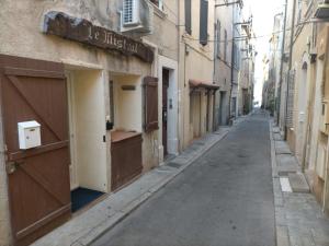una calle vacía en un callejón con un edificio en Le Mistral location, en La Ciotat