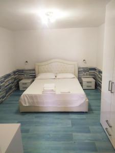 um quarto com uma cama branca e duas mesas de cabeceira em La terrazza sul mare em Marina di Camerota