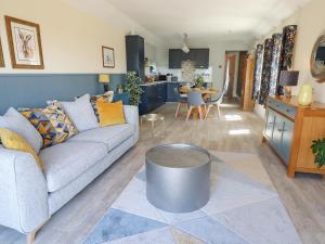 a living room with a couch and a table at Whileaway Cottage in Looe