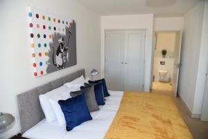 a bedroom with a large bed with blue pillows at FANTASTIC 2 Dbl Bedroom Apt. FREE off-road parking in Swindon