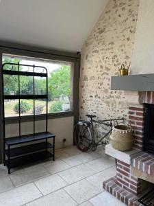 um quarto com lareira e uma bicicleta ao lado de uma janela em Une pause s'impose ;) em Méry-sur-Cher