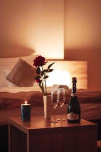 a table with a bottle of wine and two glasses at Centrooms Eger in Eger