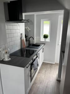 a kitchen with a sink and a stove top oven at Quay Cottage in Parkgate