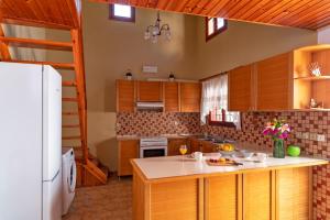 uma cozinha com armários de madeira e um frigorífico branco em Traditional 3 bedroom house in the Old Town in Ilha de Rhodes