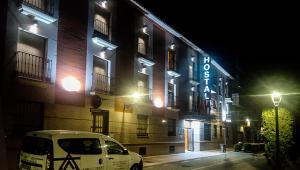 a white van parked in front of a building at night at Hostal Plaza Mayor in Torrejón de Ardoz
