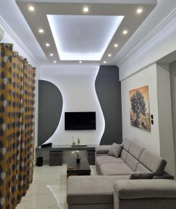 een woonkamer met een bank en een tv bij Jenny's Dream Home -Acropolis Lux 2 Bedroom Apt, with Hot Tub, free Netflix, fast Wifi in Athene