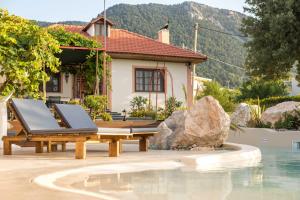 a pool with a table and a bench next to a house at Old Nest House in Sálakos