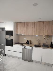 eine Küche mit weißen Schränken und Geräten aus Edelstahl in der Unterkunft Casinha das Bonecas By Viva a Vida - Alojamentos & Hotels in Constância