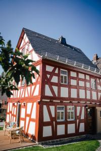 czerwono-biały budynek z drewnianym tarasem w obiekcie Fachwerkhaus w mieście Rettert