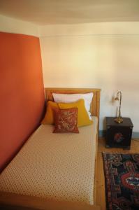 a bed with colorful pillows on it in a room at Fachwerkhaus in Rettert