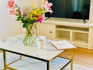 een vaas met bloemen op een tafel met een tv bij Ferien-Apartment Silberweide mit Privatstrand in Friedrichshafen