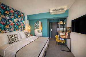 1 dormitorio con 1 cama grande y pared colorida en DALMACIJA PLACES HOTEL by Valamar, en Makarska