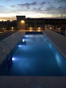 a swimming pool on the roof of a building at night at Monoambiente en La Boca. in Buenos Aires