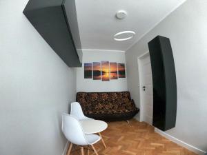 a living room with a couch and two white chairs at Faryna Apartament in Ruciane-Nida