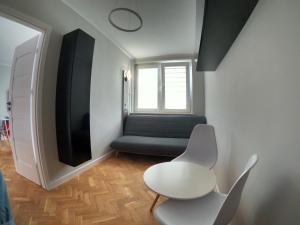 a living room with a chair and a tv at Faryna Apartament in Ruciane-Nida
