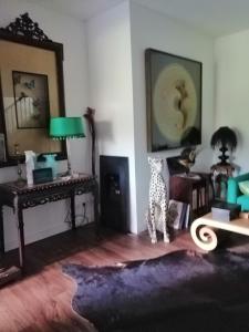 - un salon avec une table et une statue de girafe dans l'établissement Maison de charme, à Bordeaux