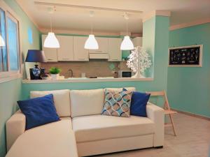 a living room with a white couch with blue pillows at Il Bounty - struttura per soggiorni brevi - in Fontane Bianche