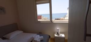 a bedroom with a bed and a window with the ocean at B&B Centrale in Gallipoli