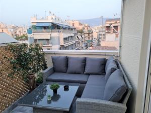 een balkon met een bank en een tafel op een dak bij Jenny's Dream Home -Acropolis Lux 2 Bedroom Apt, with Hot Tub, free Netflix, fast Wifi in Athene