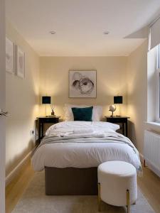 a bedroom with a large bed with two tables and two chairs at Beautiful & cosy 4 bedroom home in Todmorden