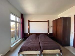 a bedroom with a bed and a large window at Vakantiecentrum Zeelinde in De Haan